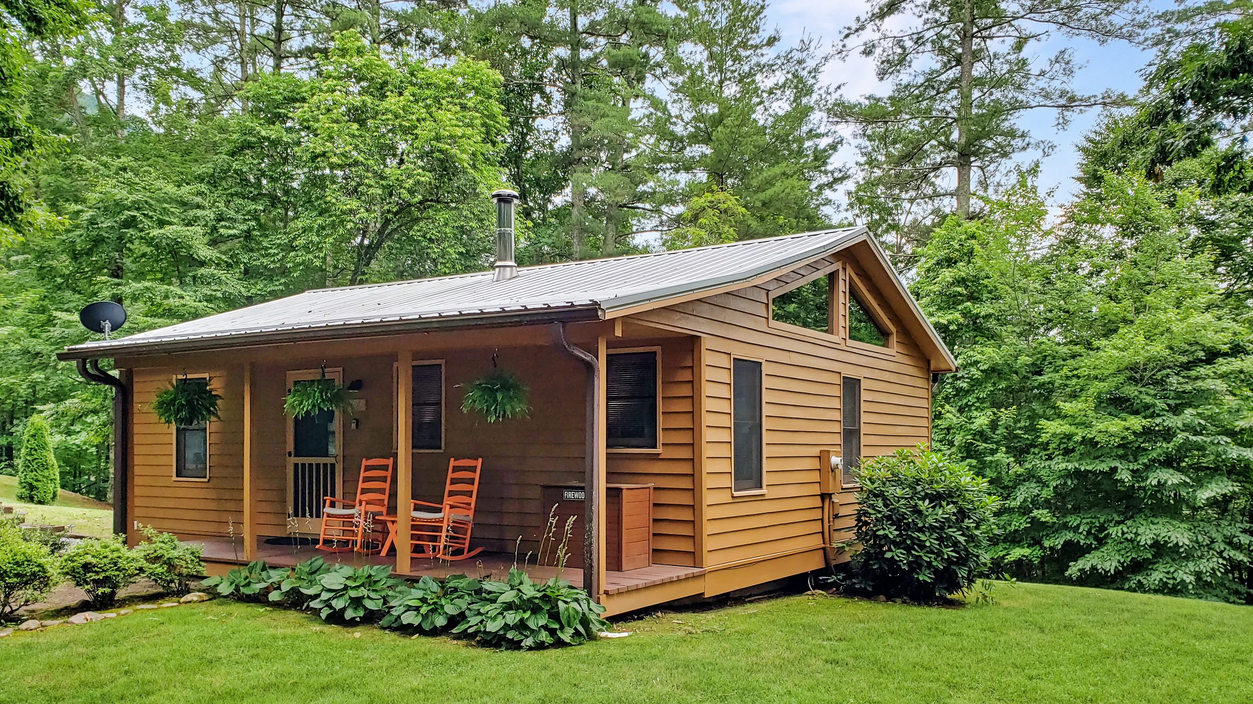 A cabin in the woods with orange rocking chairs